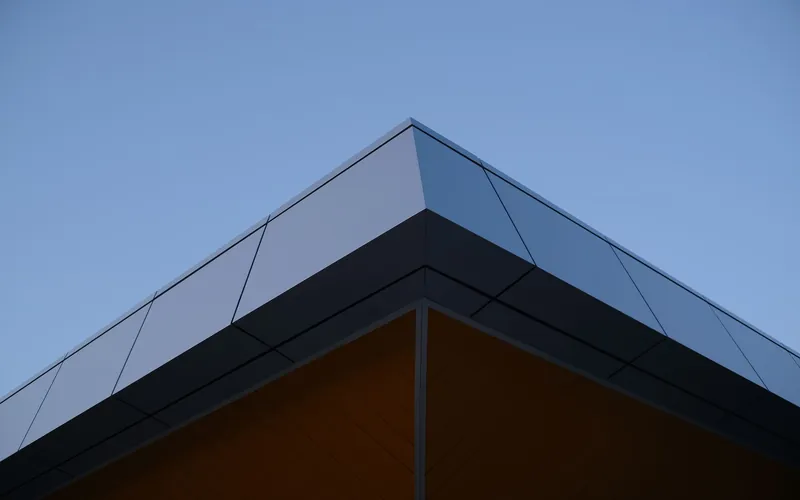 A flat roof membrane turned up against a brick wall at an upstand